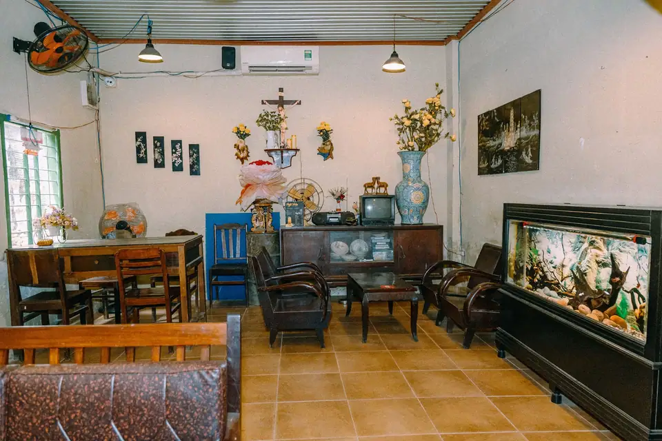 A long planted aquarium on a low cabinet along the wall of a tiled living room